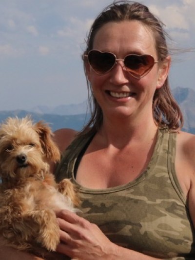 a woman holding a dog wearing sunglasses